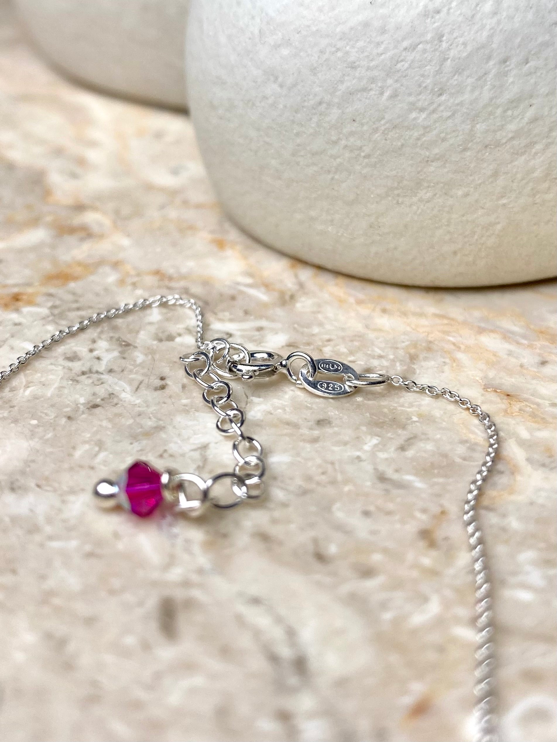 Lähikuva siron hopeisen kaulakorun lukosta