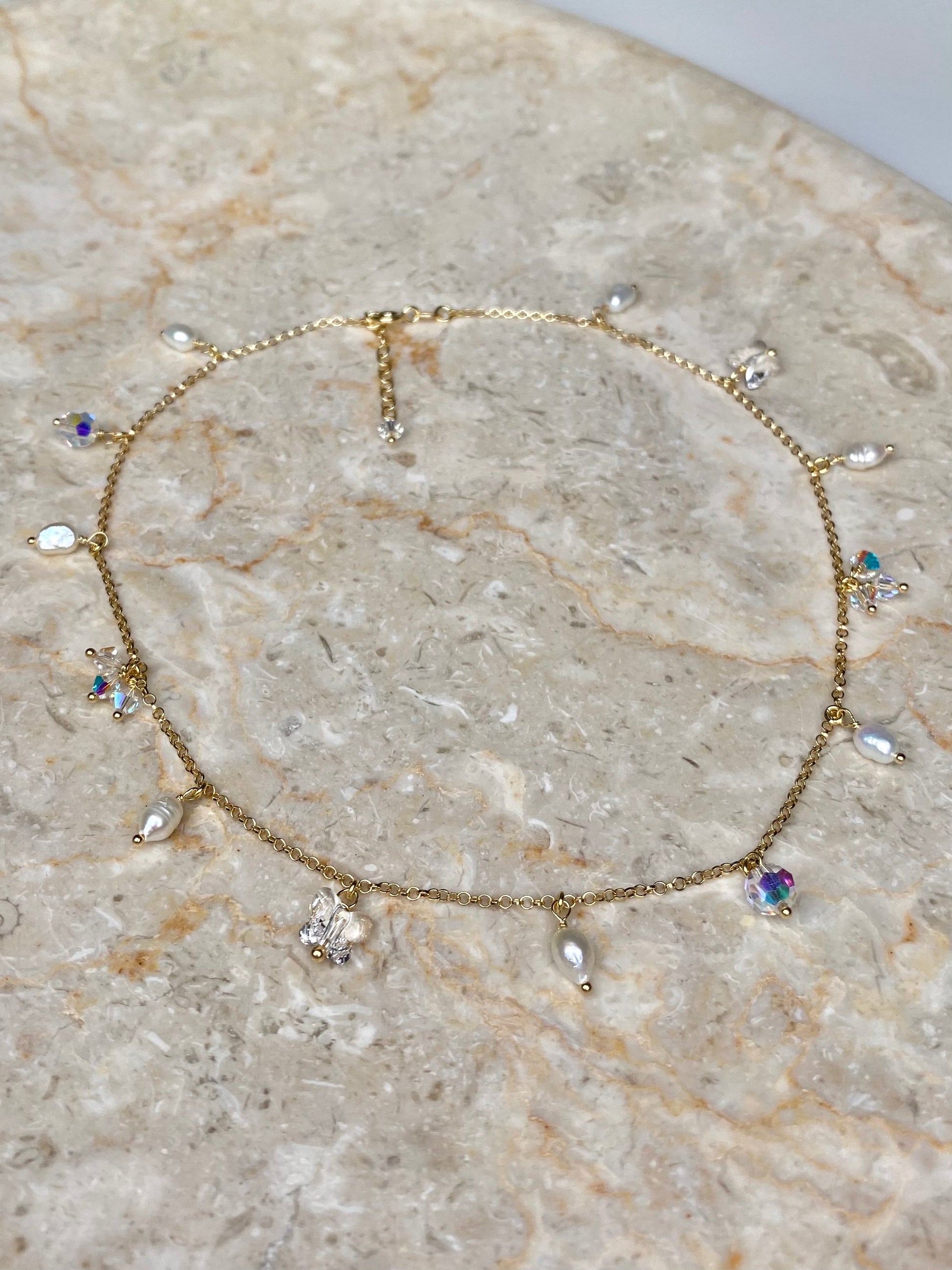 Siro kultainen kaulakoru, joka on tehty kullatusta hopeasta, kristalleista ja helmistä