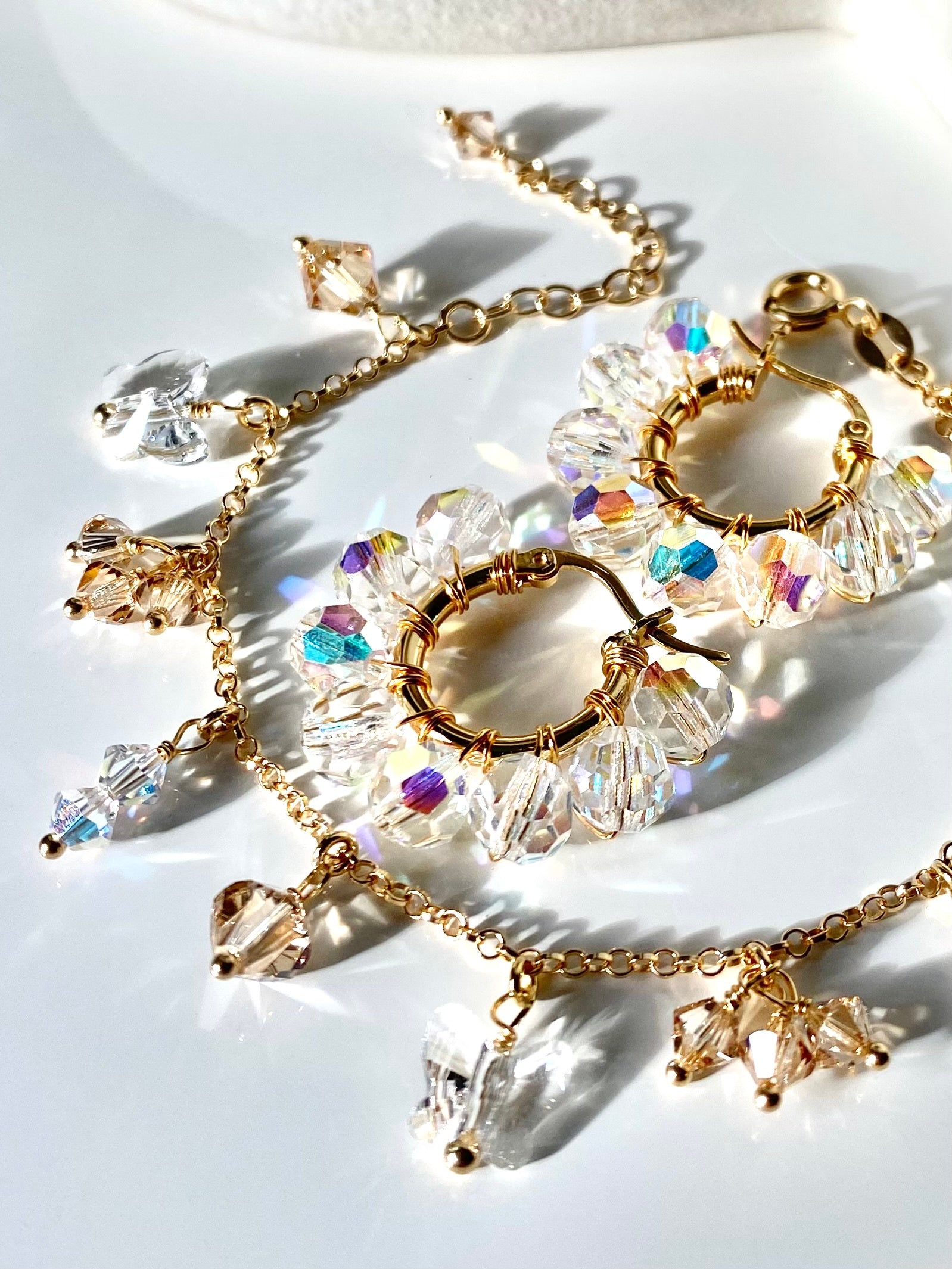 Beige rannekoru ja kirkkaat korvakorut