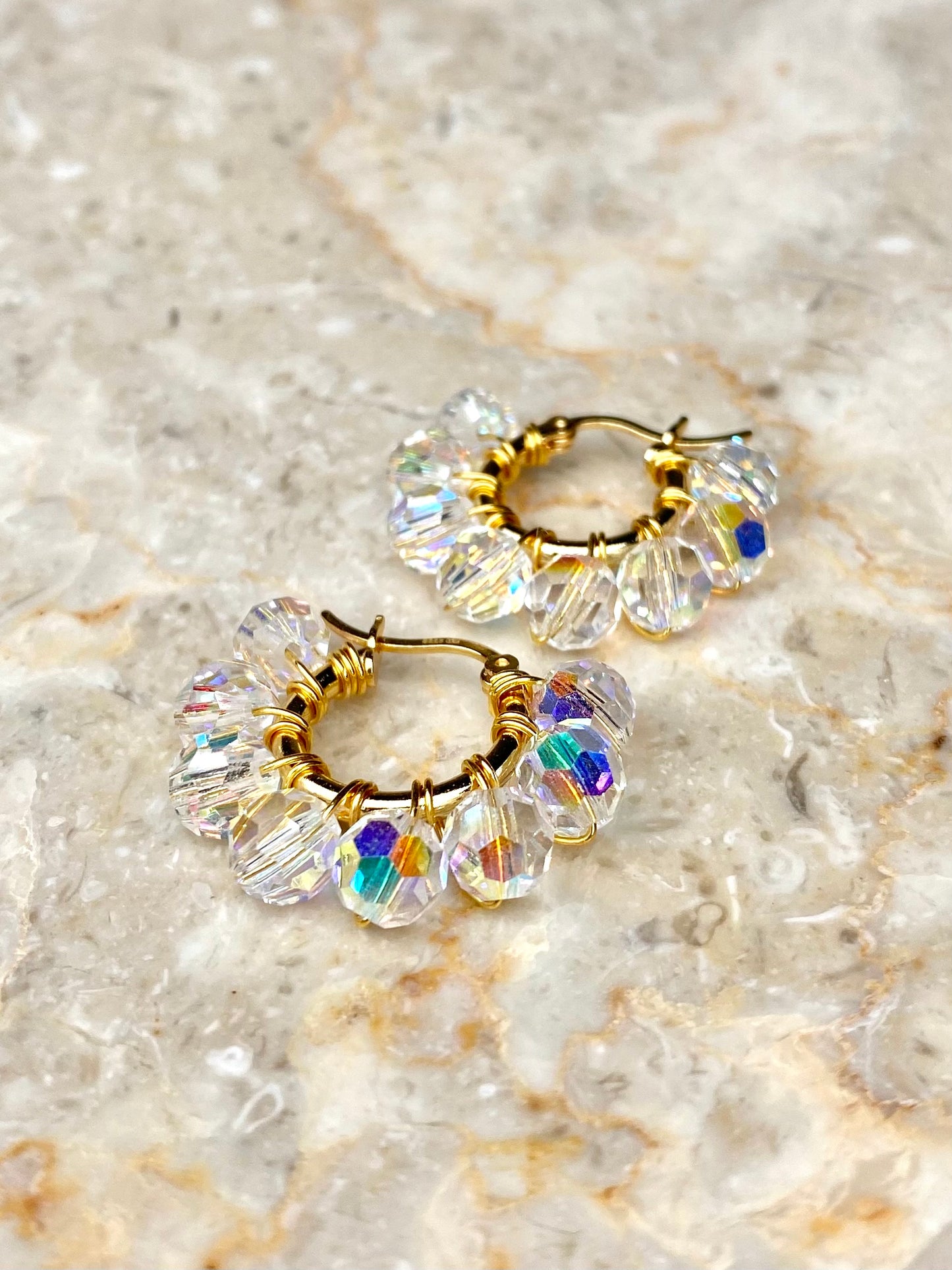 Kullatut hopeiset korvakorut kirkkailla kristallihelmillä