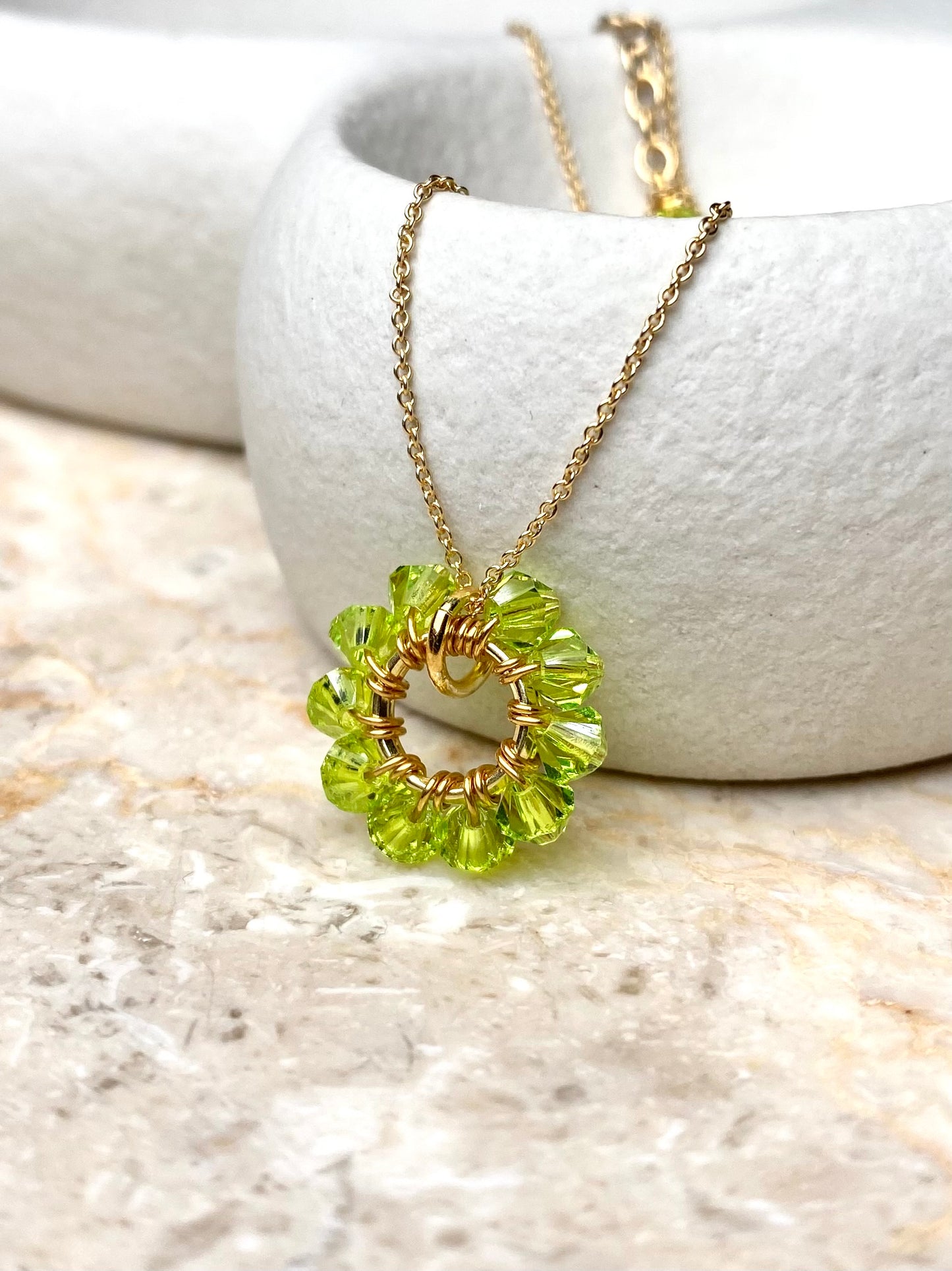 Lähikuva vaaleanvihreästä kaulakoruriipuksesta