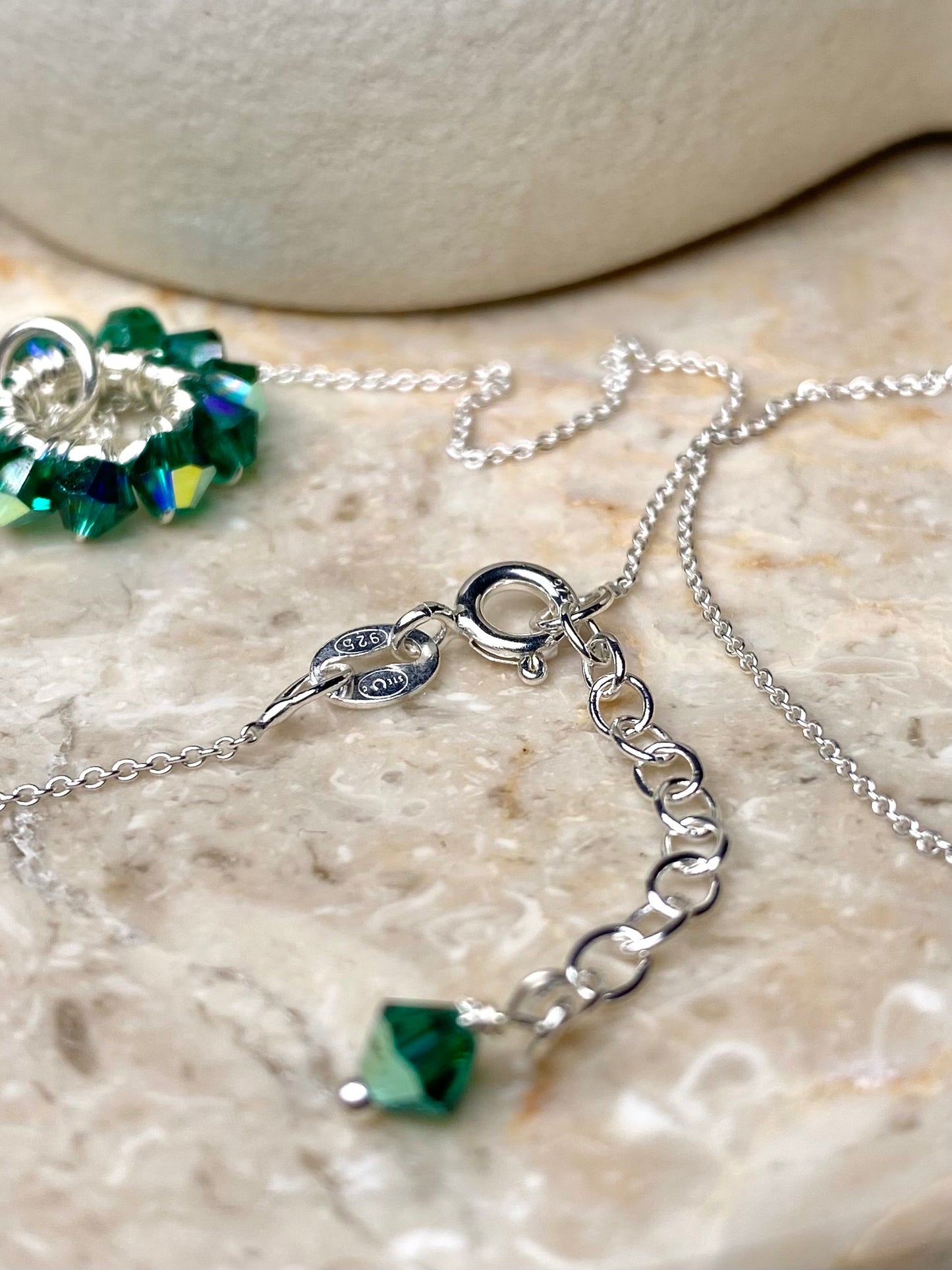 Lähikuva tummanvihreän kaulakorun yksityiskohdasta