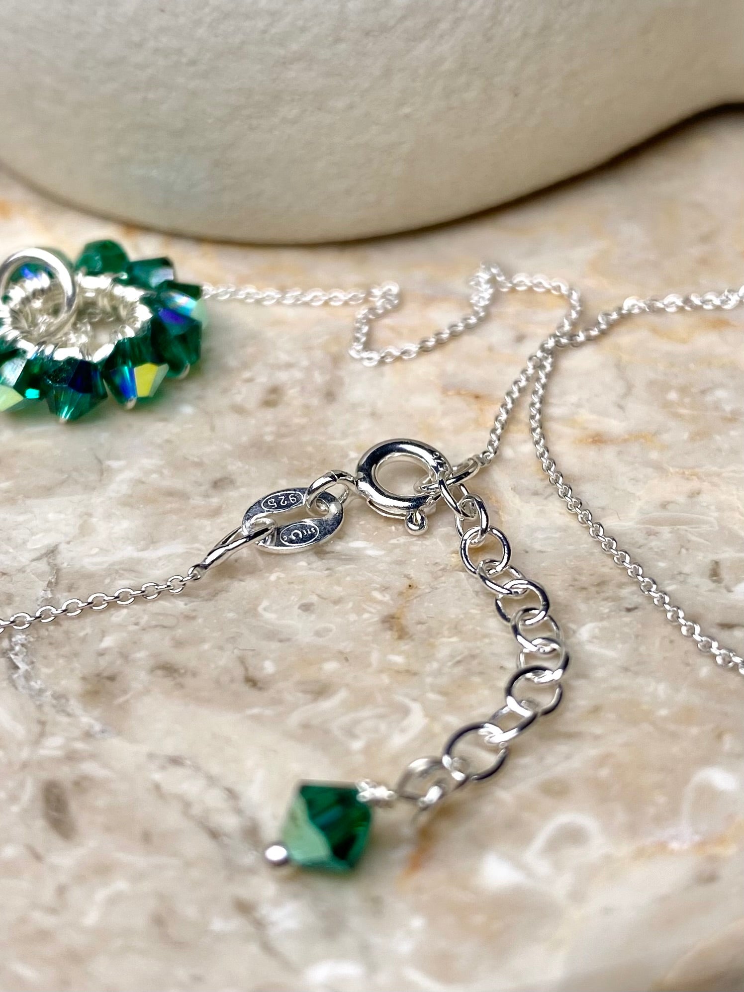 Lähikuva tummanvihreän kaulakorun yksityiskohdasta