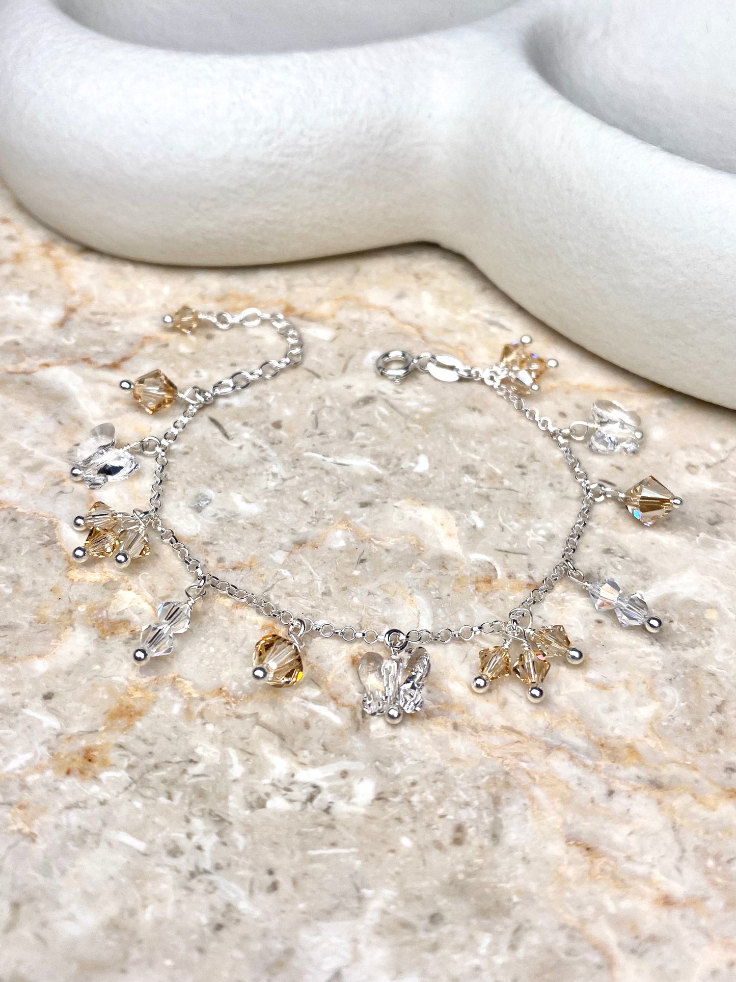 Hopeinen rannekoru beigeillä kristallikoristeilla