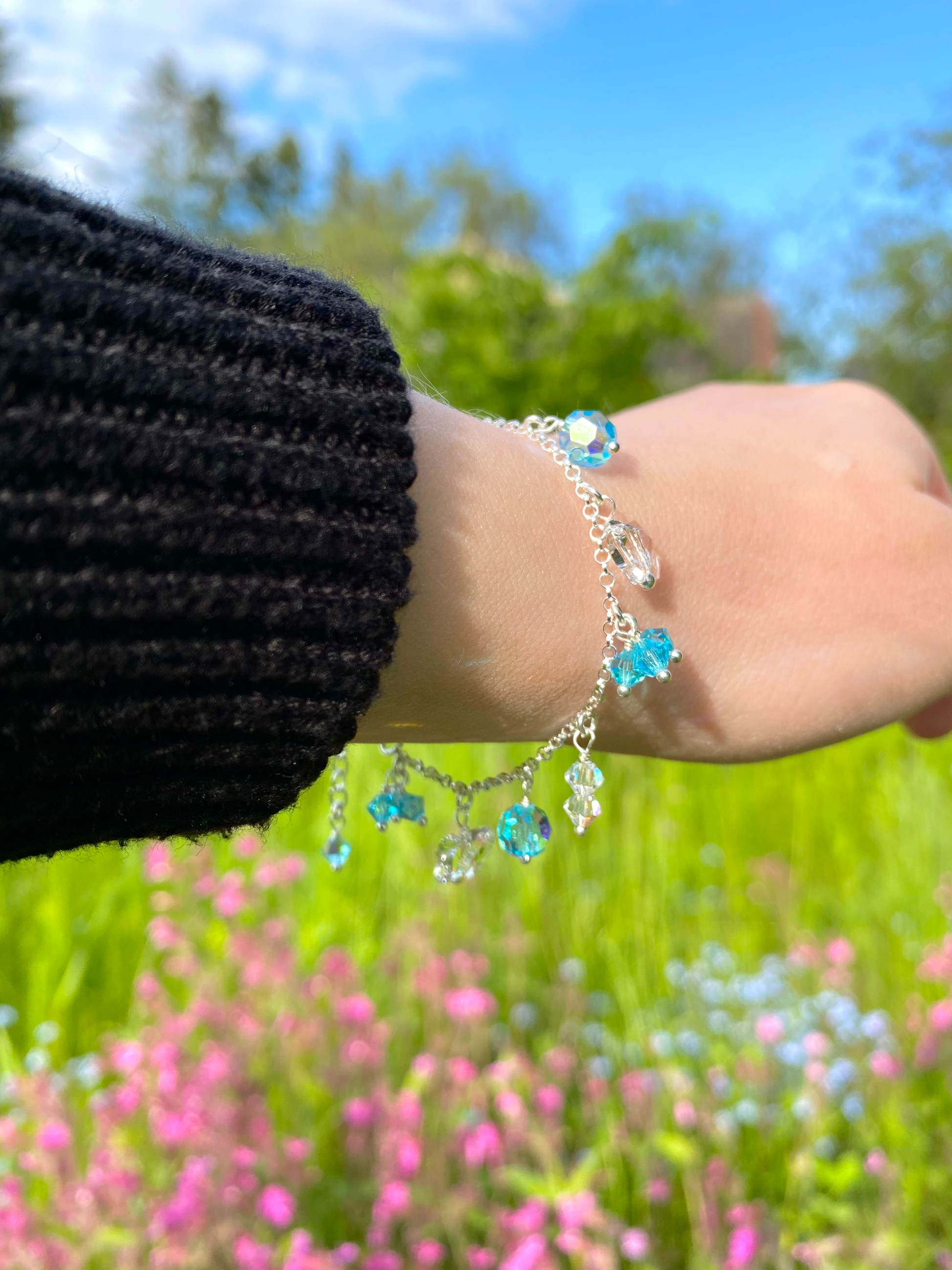 Hopeinen turkoosi riipusrannekoru mallin ranteessa