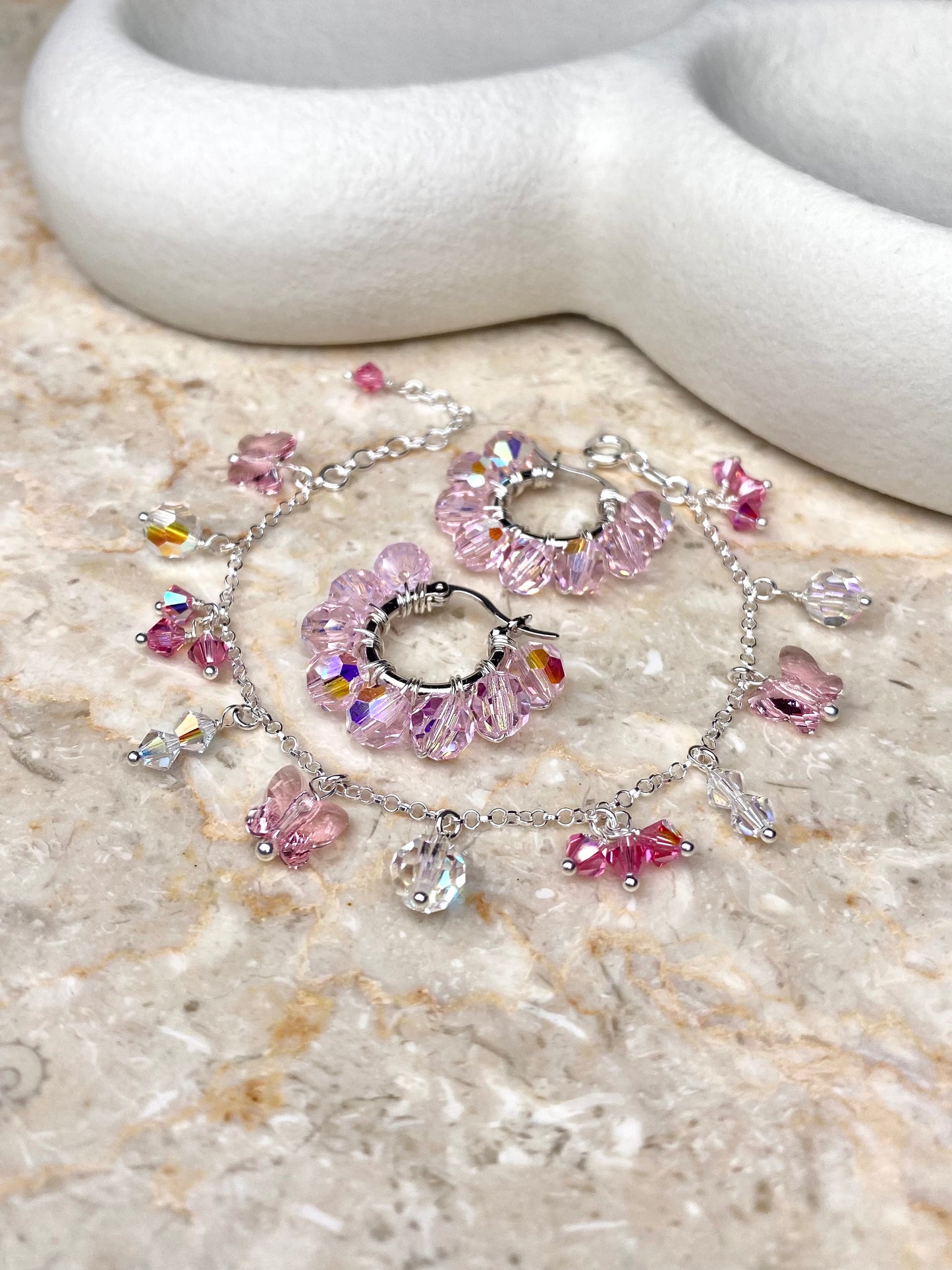 Vaaleanpunainen korusetti, joka on tehty hopeasta