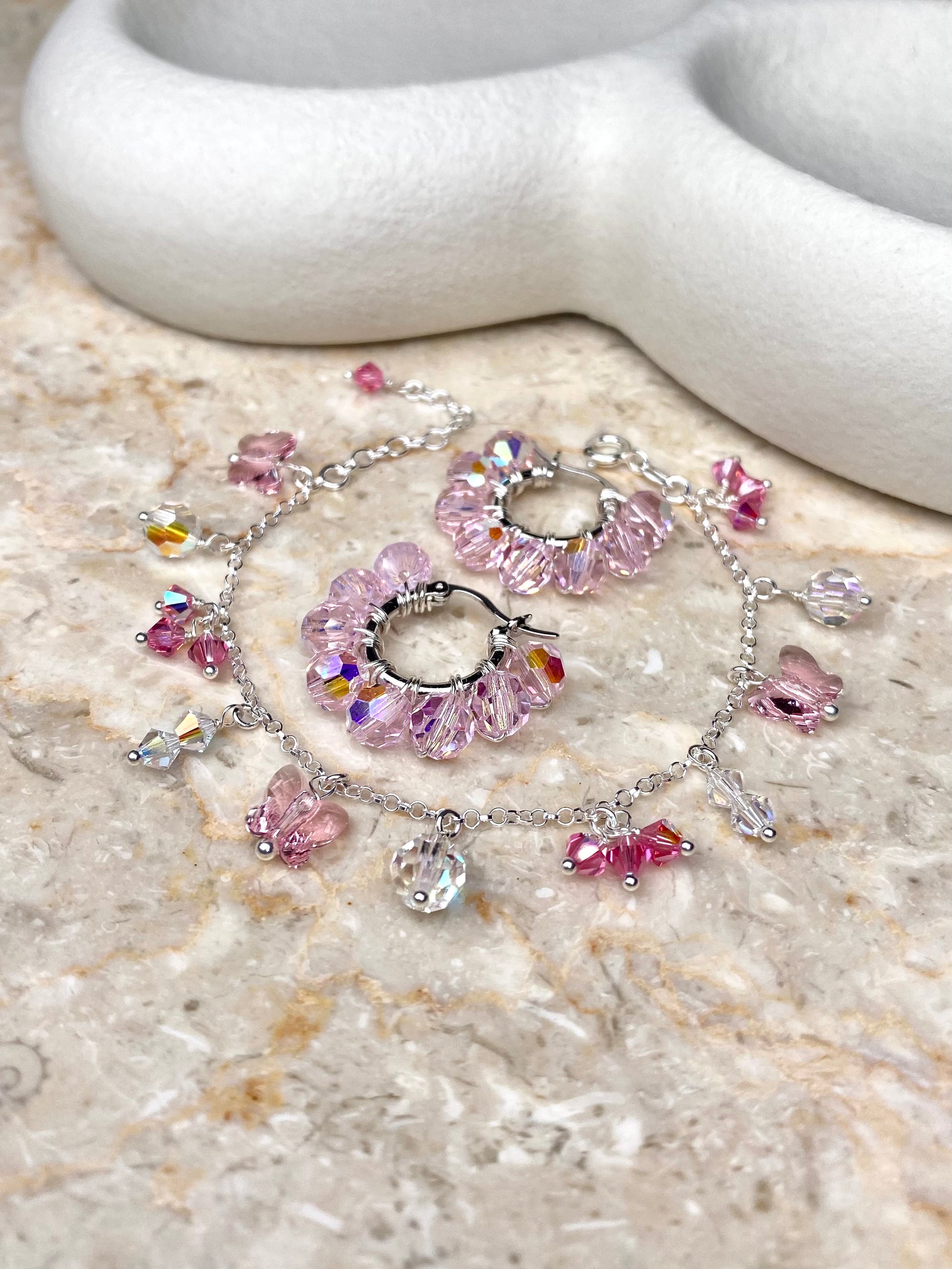 Vaaleanpunainen korusetti, joka on tehty hopeasta