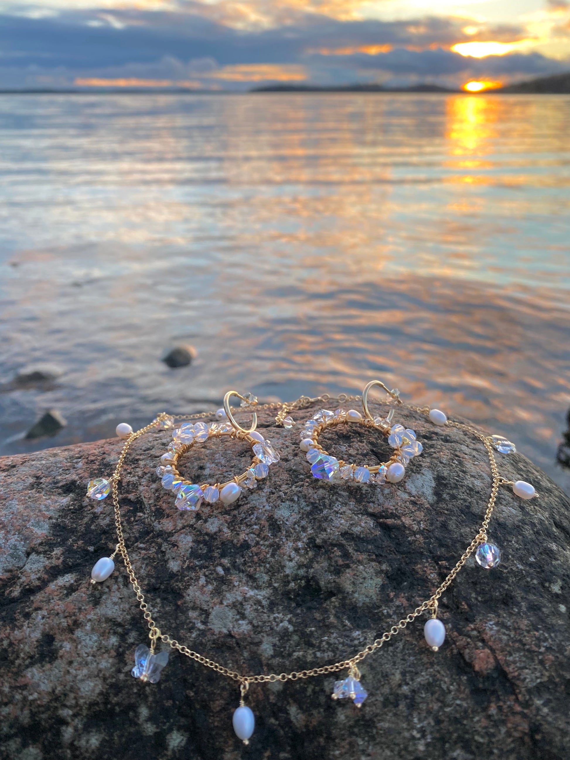 Kultainen korusetti kuvattu kiven päällä, korvakorut ja kaulakoru