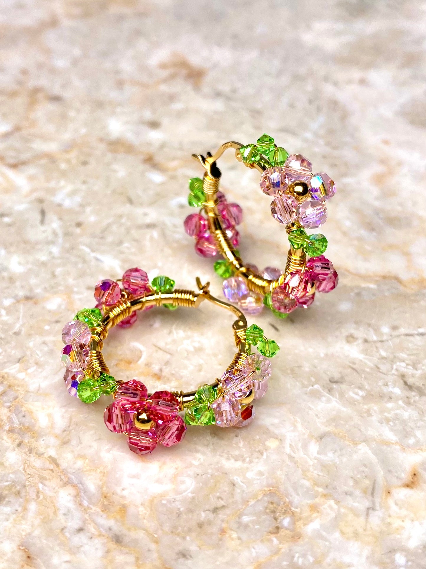 Vaaleanpunaiset kukkakorvakorut, jotka on tehty kullatusta hopeasta