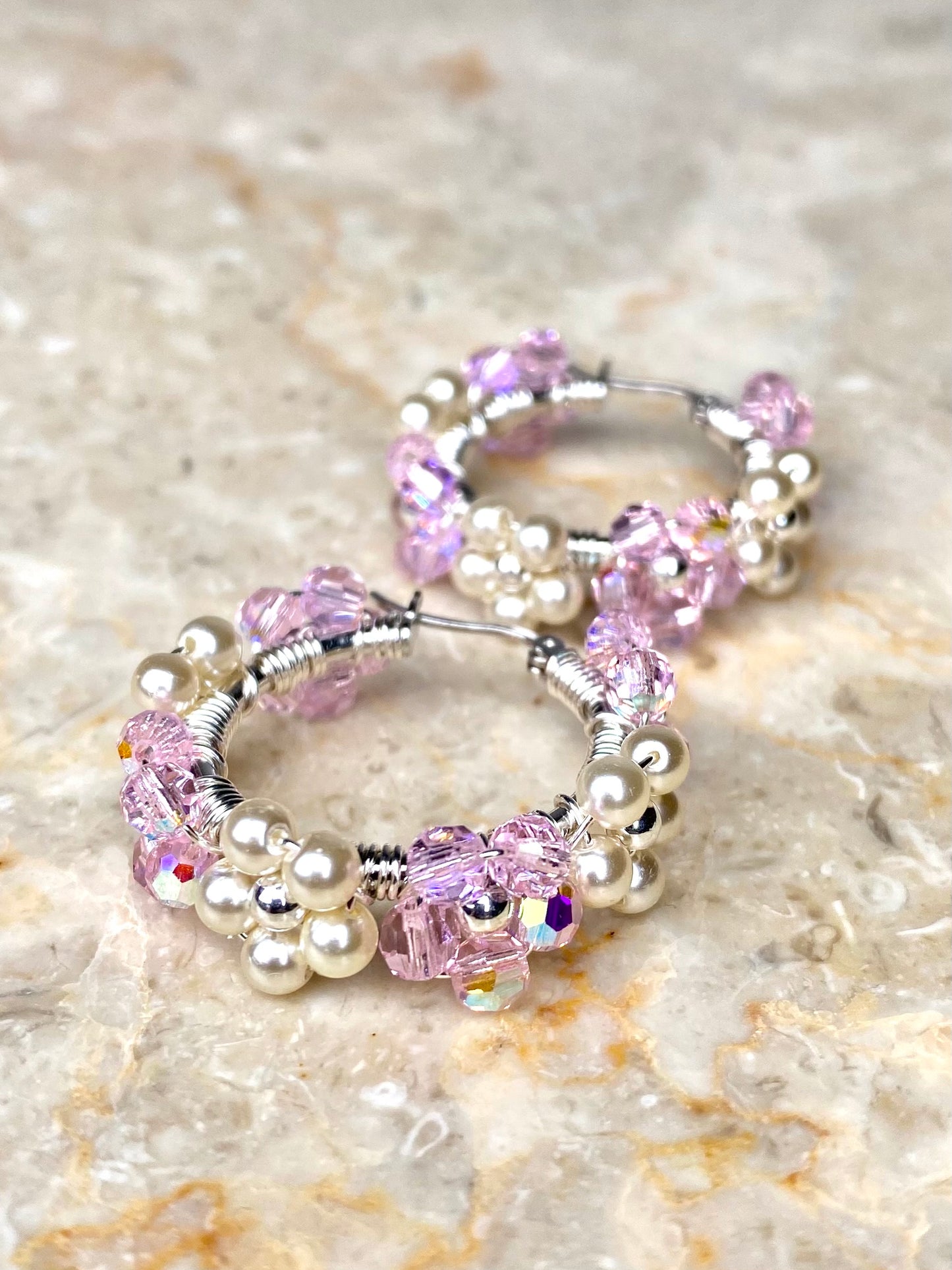 Lähikuva hopeisista korvakoruista, koristeltu kukilla