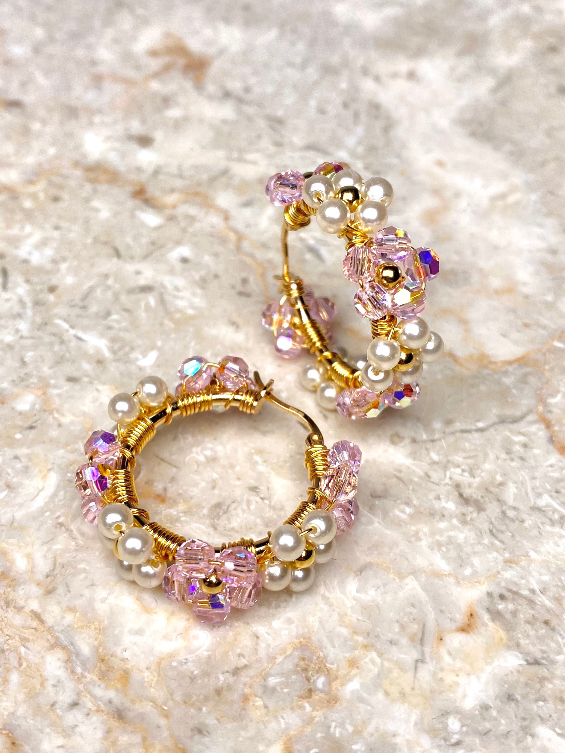 Kulltut korvakorut vaaleanpunaisilla ja helmiäisen värisillä kristallikukilla