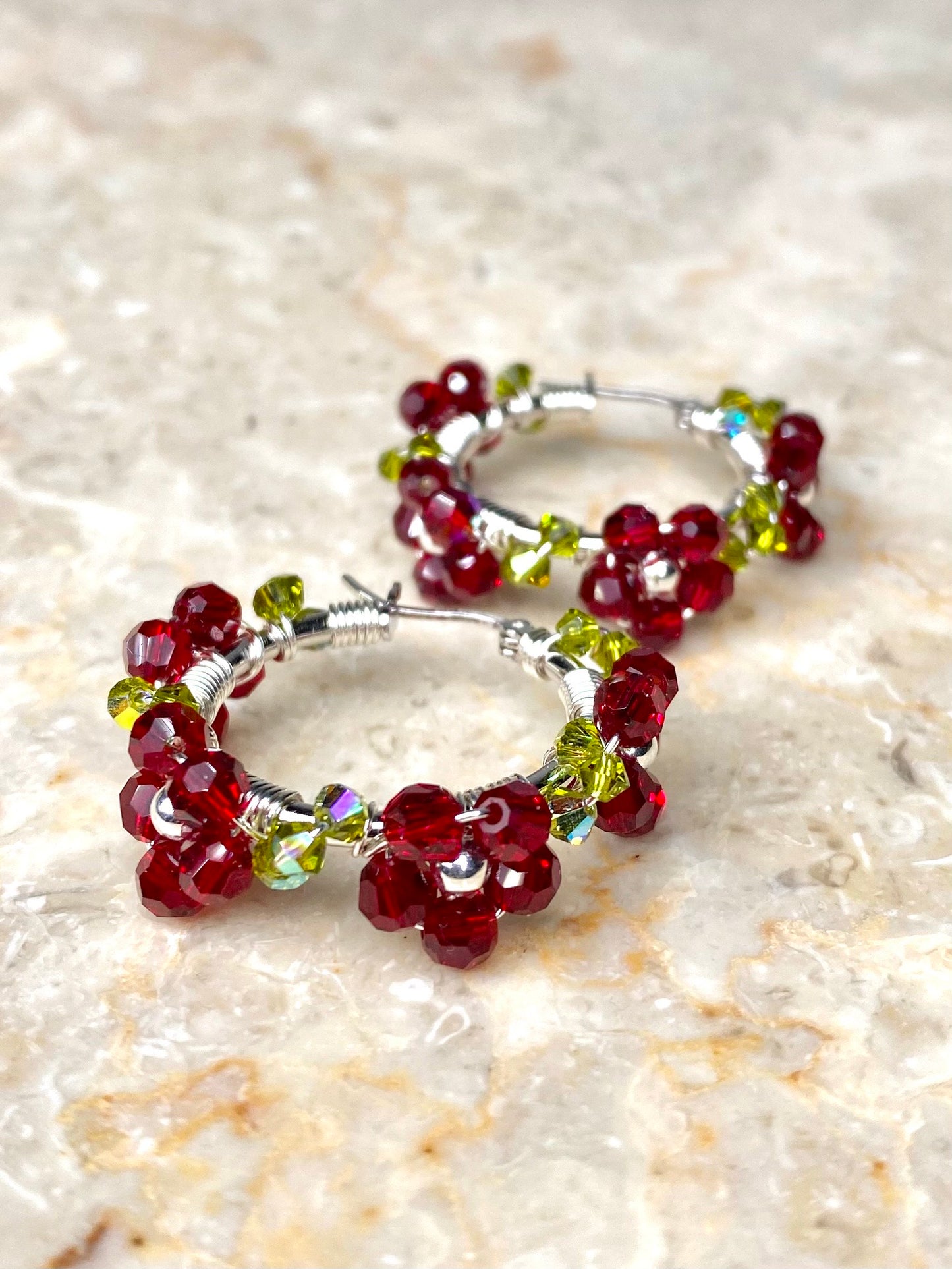 Hopeiset rengaskorvakorut, koristeltu tummanpunaisilla kukilla