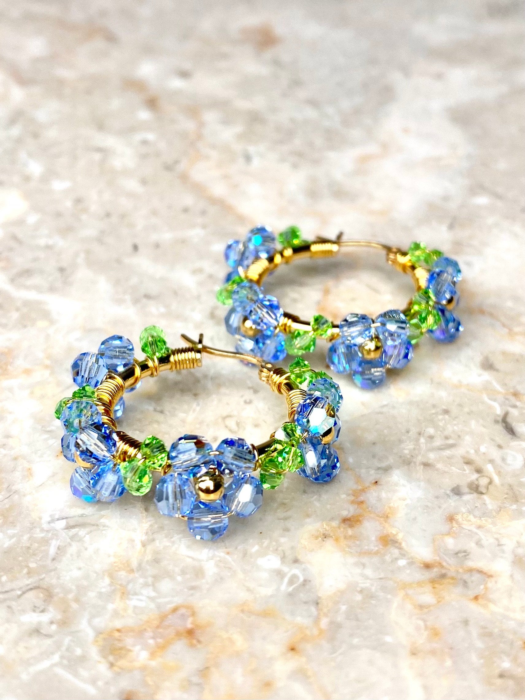 Kullatusta hopeasta tehdyt vaaleansiniset kukkakorvakorut, lähikuva