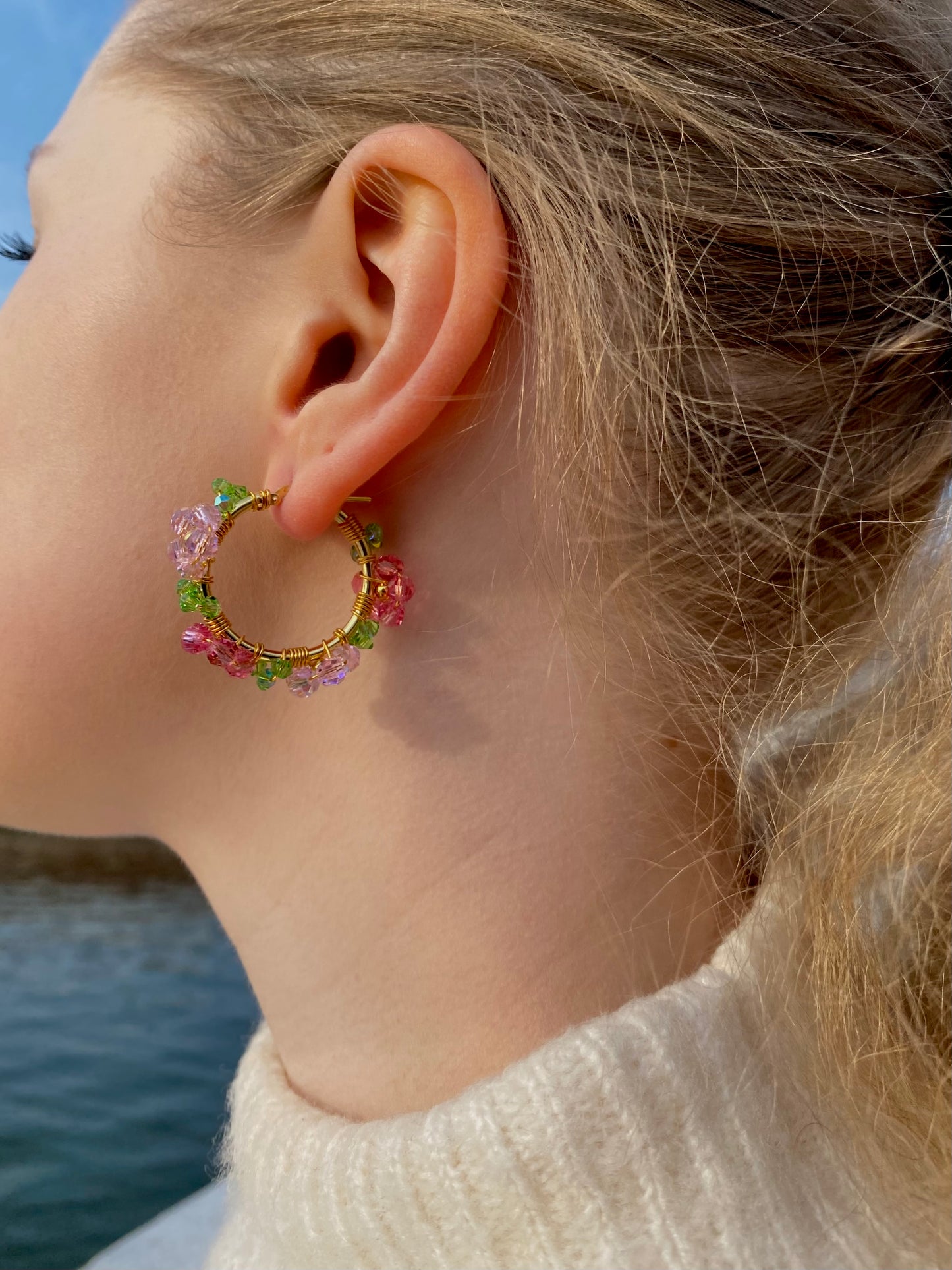 Kultaiset vaaleanpunaiset kristallikukkakorvakorut mallin korvissa