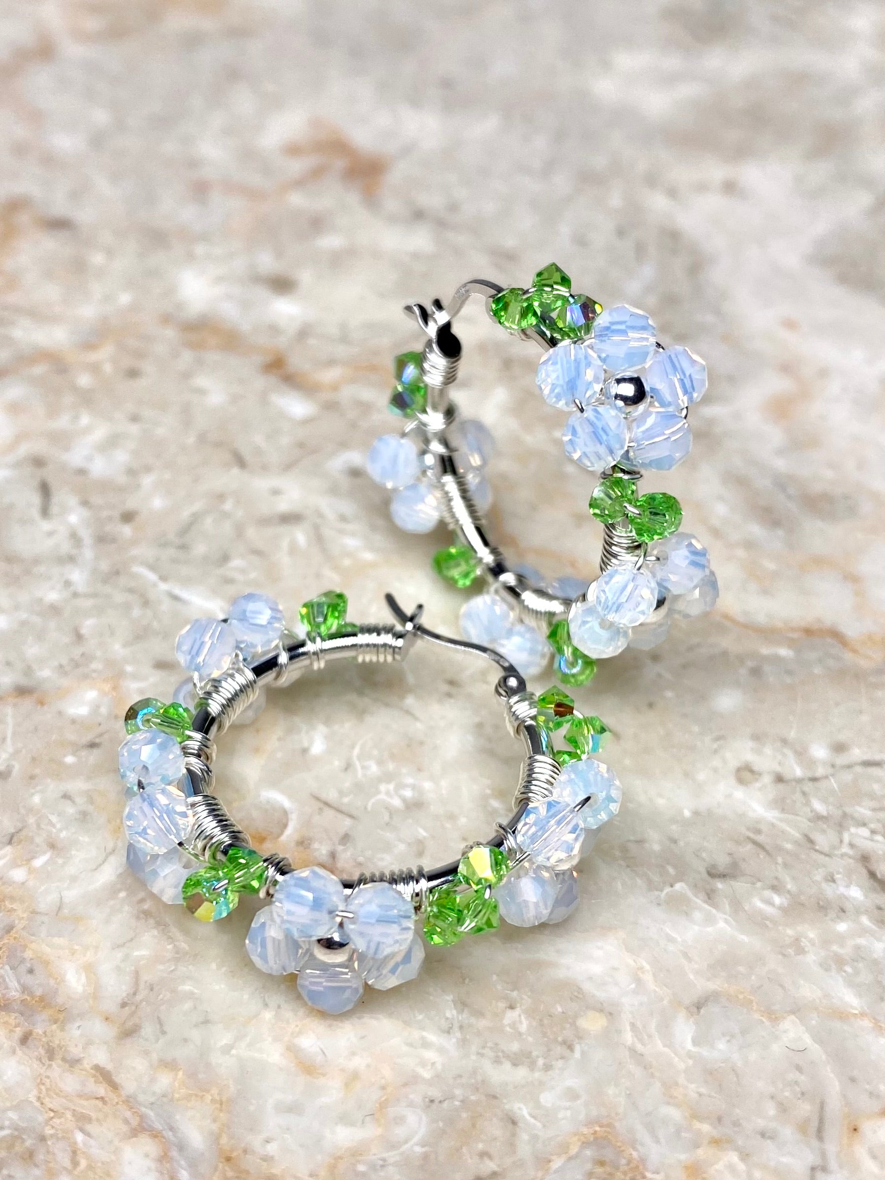 Hopeiset rengaskorvakorut valkoisilla kristallikukilla koristeltuna