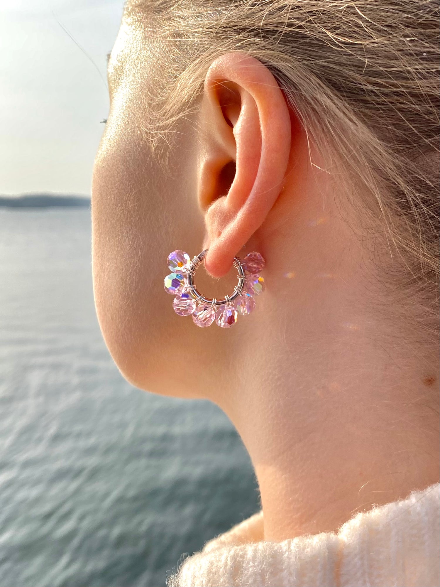 Hopeinen vaaleanpunainen korvakoru mallin korvassa