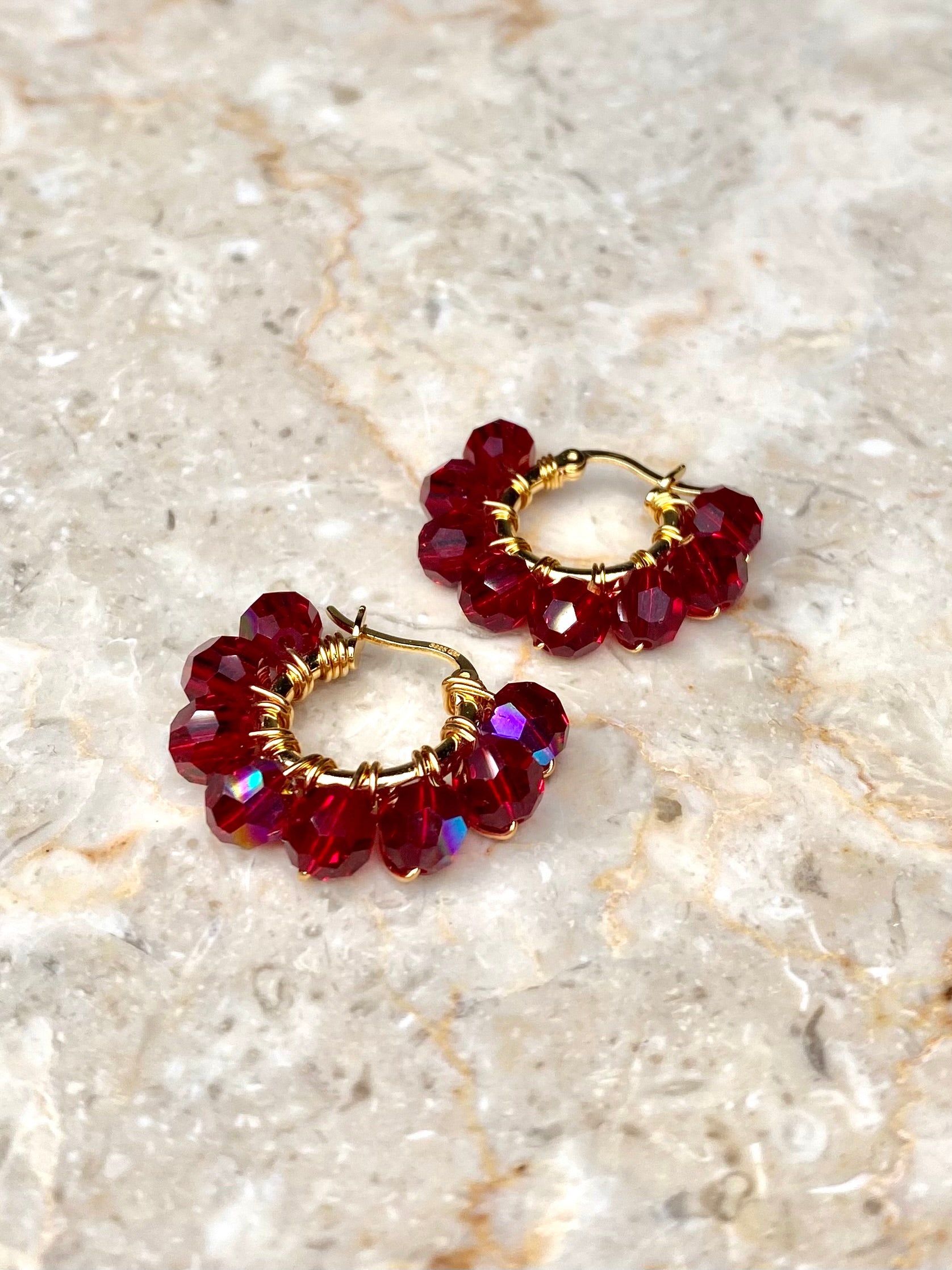 Tummanpunaiset korvakorut, jotka on tehty kullatusta hopeasta