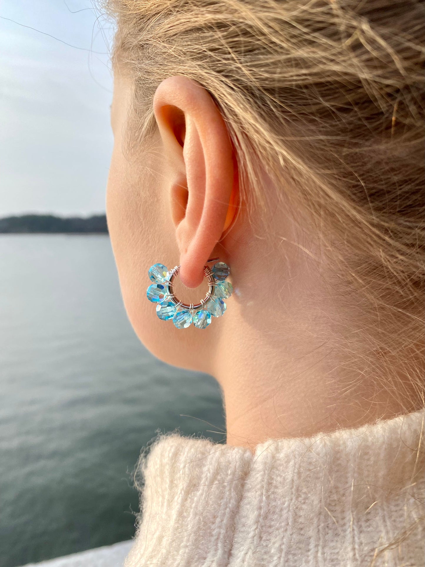 Hopeiset turkoosit korvakorut, kuvattu mallin korvassa