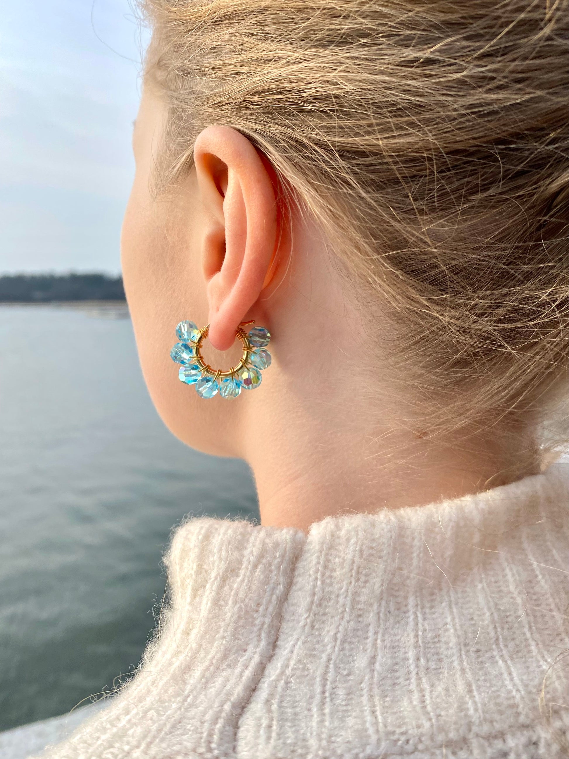 Pienet turkoosit kultaiset korvakorut mallin korvassa