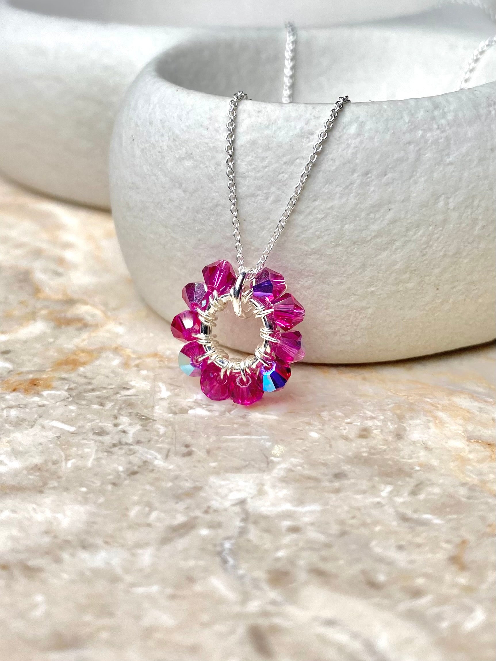 Ronja Selina -merkin pinkki hopeinen kaulakoru, lähikuva kaulakorun kristalliriipuksesta