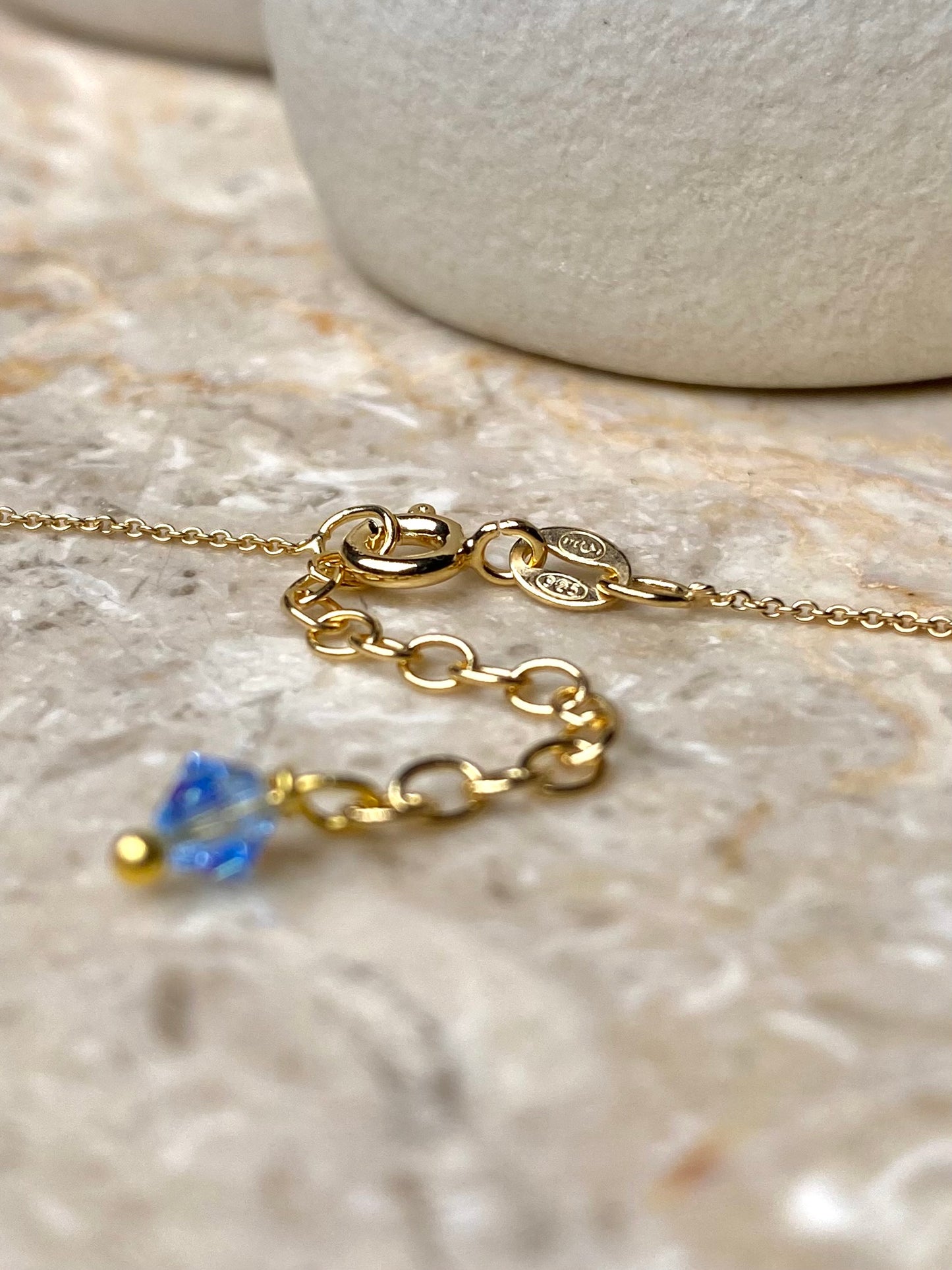 Lähikuva kultaisen kaulakorun sirosta lukosta