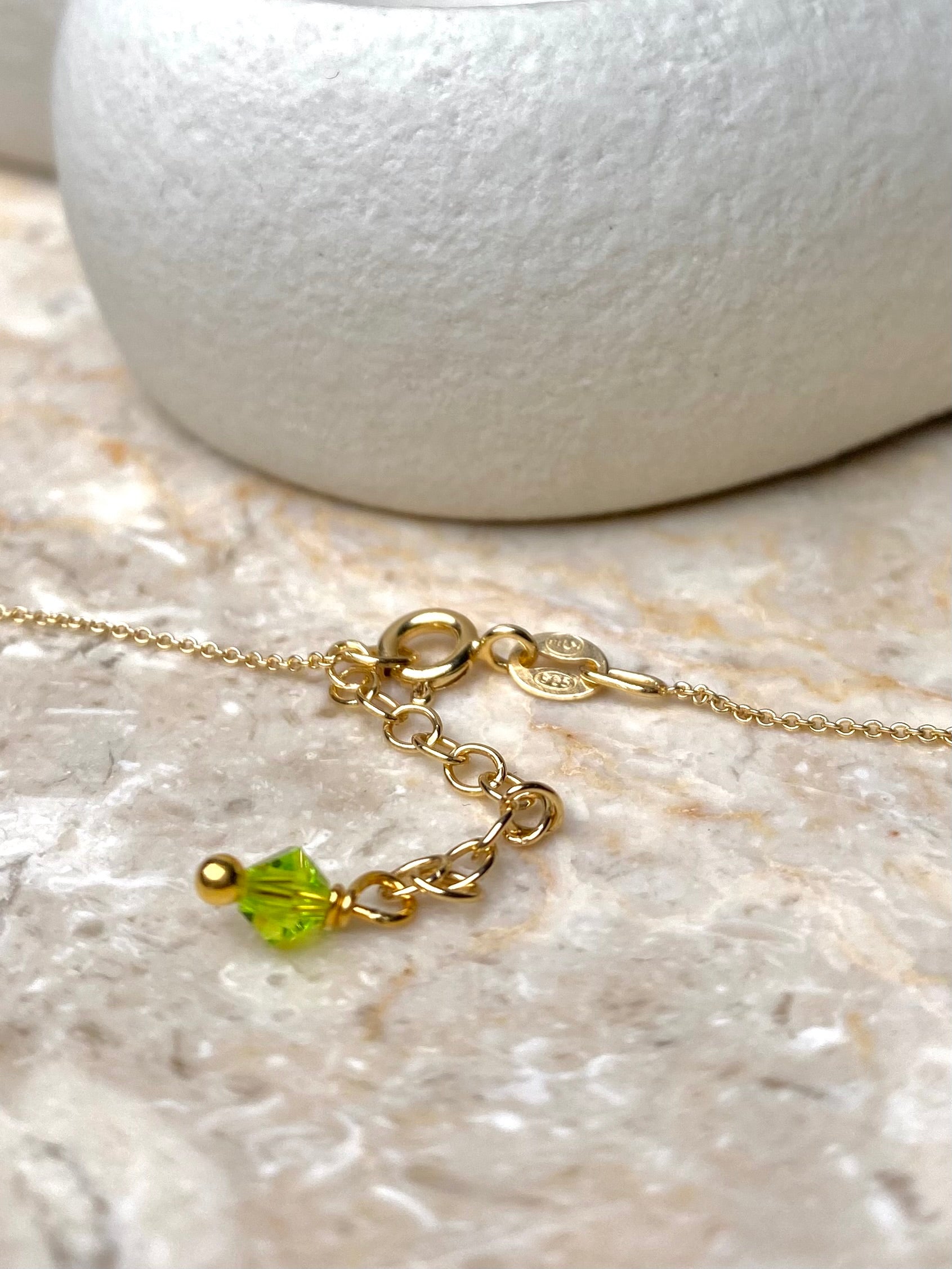 Lähikuva limenvihreän kaulakorun sirosta lukosta