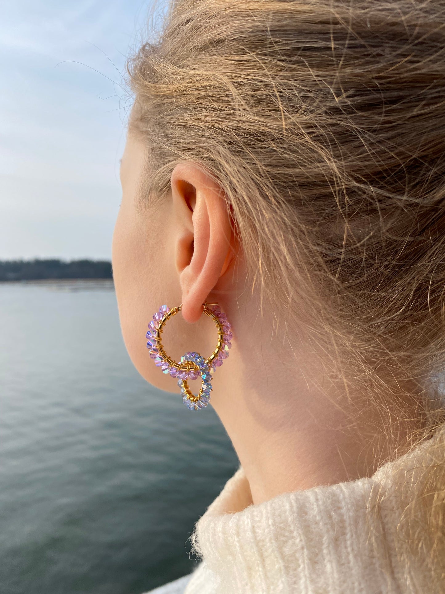 Tuplarengaskorvakorut mallin korvassa, lila ja vaaleansininen