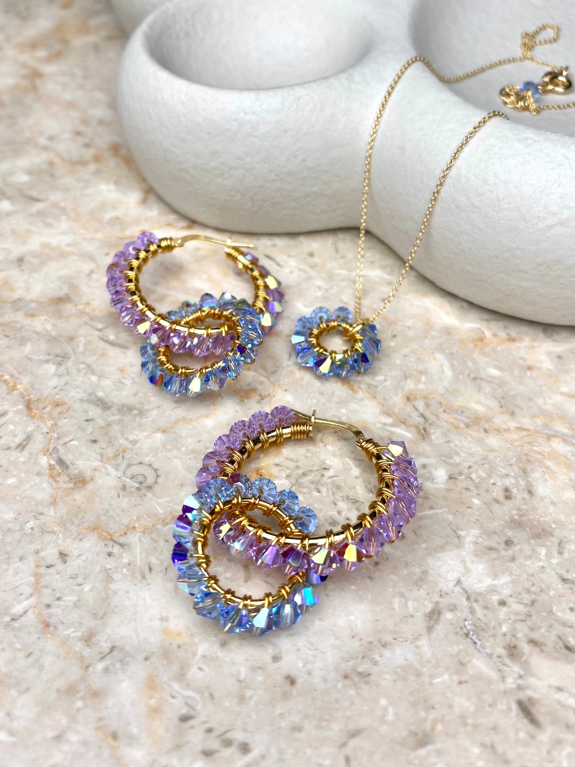 Kullattu hopea korusetti, jossa on vaaleansininen kaulakoru ja sinililat korvakorut